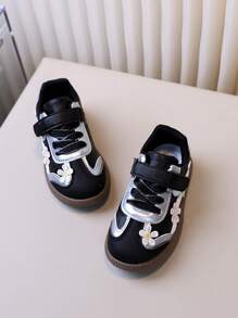 زوج من أحذية الأطفال الرياضية للتزلج بتطريز أسود للبنات