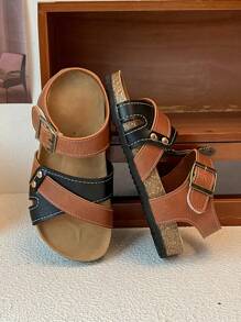 This Is A Pair Of Best-Selling Girls' Sandals. The Upper Is Made Of Brown And Black Leather. The Cross-Strap Design Adds A Sense Of Layering, And It Is Equipped With Metal Buckles To Adjust The Tightness. It Is Convenient To Put On And Take Off. The Upper Layer Of The Sole Is Made Of Cork, Which Fits The Feet Closely And Provides Comfort.