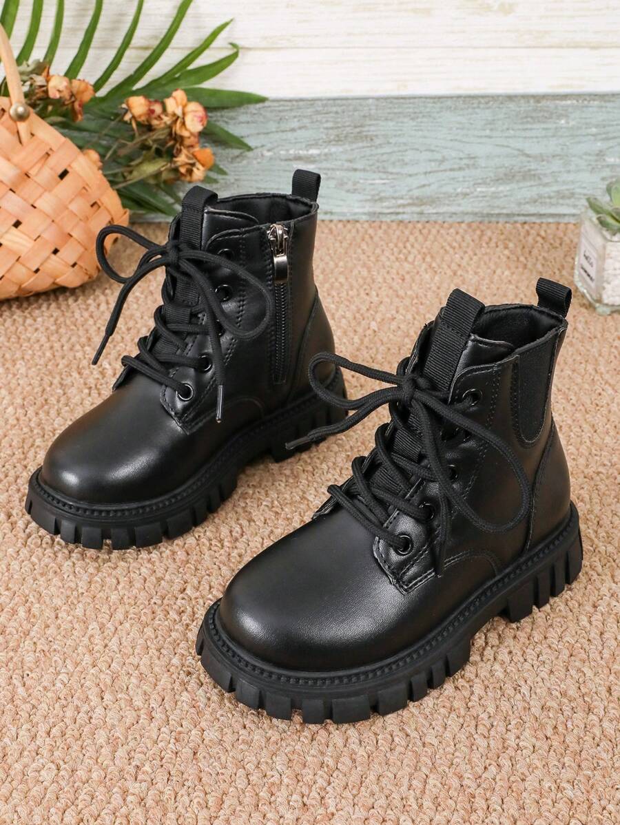 This Is A Pair Of Short Boots. The Upper Material Looks Like Leather. It Adopts A Design With Laces And A Side Zipper, Which Is Convenient For Children To Put On And Take Off. The Sole Is Thick With Obvious Patterns, Enhancing The Grip And Stability Of The Shoes.
