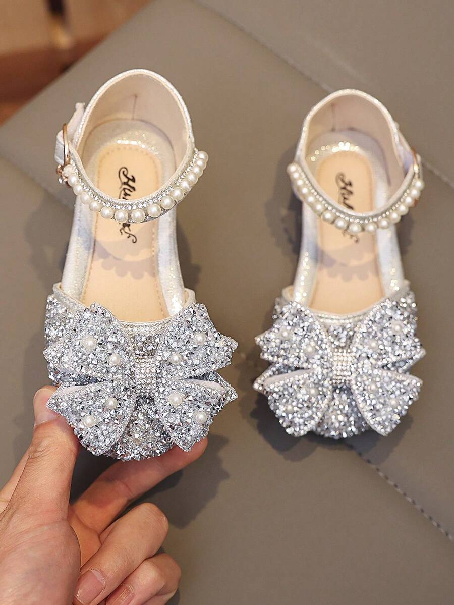 1 Đôi dép xăng đan đế bằng màu hồng thời trang mới, đa năng, đính ngọc trai và nơ đá lấp lánh cho bé gái, mũi tròn, thích hợp cho mang hàng ngày, khiêu vũ, hoạt động ngoài trời mùa xuân và mùa thu, giày công chúa mũi kín đính kim tuyến, size nhỏ hơn bình thường. - Bạc - Xem 1