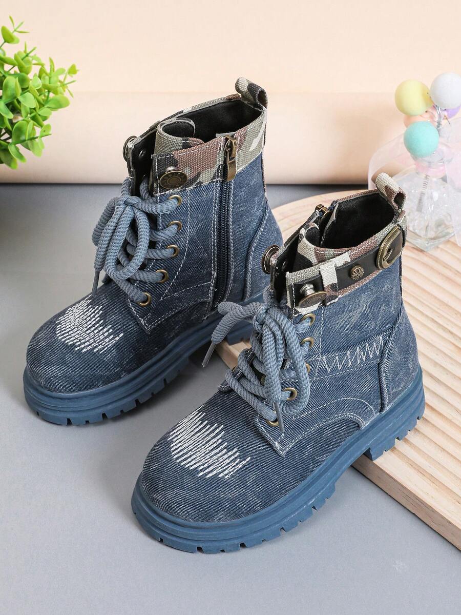 A Pair Of Stylish Children's Boots, Featuring Lace - Up And Side Zipper Designs For Easy Putting On And Taking Off; The Upper Has Decorations Such As White Stitching, And The Shoe Collar Also Has Details With Camouflage Elements. The Overall Style Leans Towards A Workwear Style, Combining Practicality With A Certain Sense Of Fashion, And Is Suitable For Children's Daily Wear And Other Scenarios.