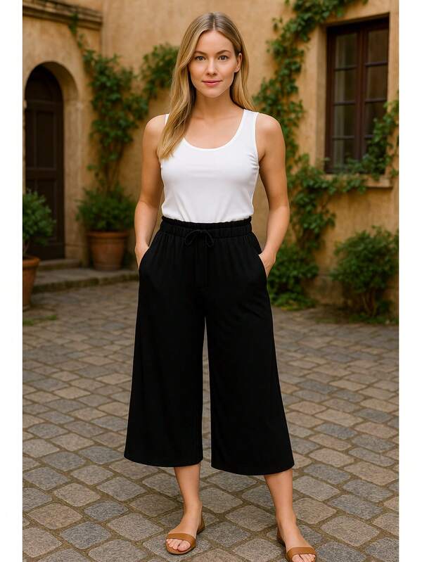 Calças capri femininas pretas de tecido de malha, com pernas largas, cordão e bolsos, modelo casual com alta elasticidade.