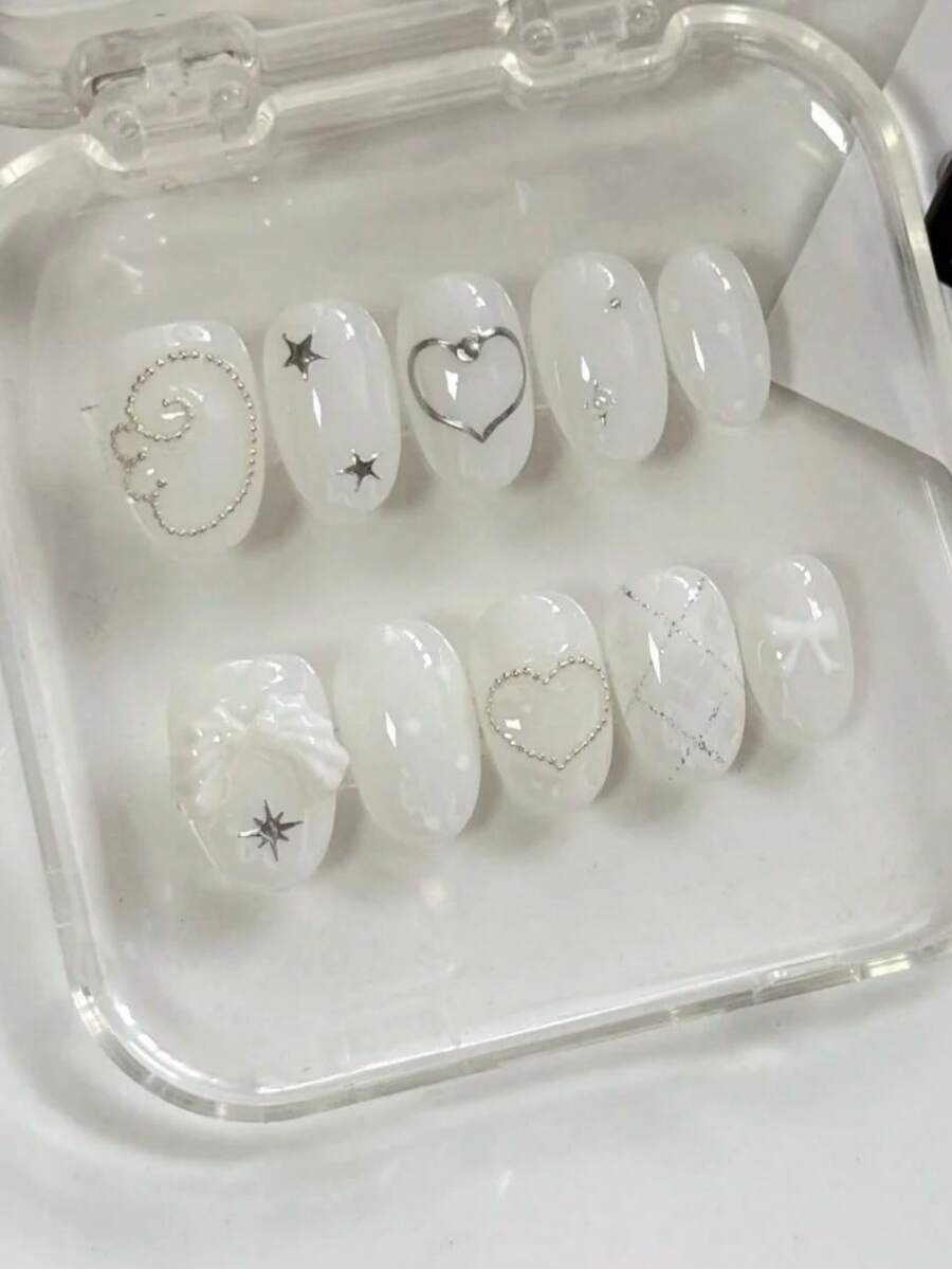 Bộ móng nghệ thuật mùa hè tươi mát và ngọt ngào này bao gồm 10 móng giả hình bầu dục ngắn. Thiết kế nổi bật với màu trắng trong suốt, được điểm xuyết bằng các đường kẻ bạc, ngôi sao và hạt kim loại nhỏ tạo hiệu ứng lấp lánh. Thêm vào đó, có đôi cánh 3D màu trắng và một chiếc nơ xinh xắn, mang đến cho móng tay vẻ ngoài ngọt ngào và thanh lịch, làm tăng thêm sự tinh tế và vẻ đẹp tổng thể của phong cách. Phụ kiện làm móng nghệ thuật có thể tái sử dụng. Móng giả thủ công. - trắng - Xem 1