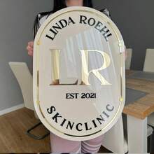 Personalisiertes beiges ovales Schild mit goldenen und schwarzen Buchstaben, goldener Umrandung, Montagematerial enthalten. Transparentes ovales Schild mit schwarzen und goldenen Buchstaben und goldener Umrandung, Montagematerial enthalten. Kundenspezifisches Acryl-Geschäftsschild für die Wand mit weißem Hintergrund, personalisiertes Geschäftsschild für das Büro