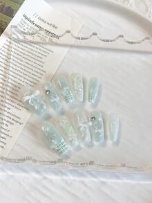 清新甜美少女风夏日美甲——10片中长棺材形美甲贴片。底色为薄荷绿，带有渐变亮片。手绘法式银色方格纹搭配白色蝴蝶结和五角星形钻石，打造精致柔美的妆容，更能衬托肤色。美甲用品 手工美甲贴片 - 薄荷綠 - 查看 2