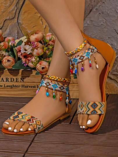 Questo è un paio di sandali piatti da donna dallo stile fortemente bohémien. La parte superiore è realizzata in tessuto intrecciato colorato, con disegni a motivi. Ci sono anche perline colorate e decorazioni appese alle cinghie intrecciate alla caviglia, che ne esaltano la moda e l'eleganza. La suola è marrone e il materiale sembra essere in pelle artificiale, adatto per essere indossato in contesti casual e da vacanza.