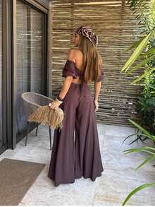 The Look That Exudes Tropical Elegance With Attitude! The Itacaré Jumpsuit Is Pure Charm For Stylish Summer Days. It Features Puff Sleeves And An Off-The-Shoulder Neckline. A Tie Detail At The Back Enhances The Silhouette. Comfort And Visual Impact In A Single Piece. Ideal For Your Clients Who Love To Stand Out With Style And Personality! - 鏽棕色 - 查看 2