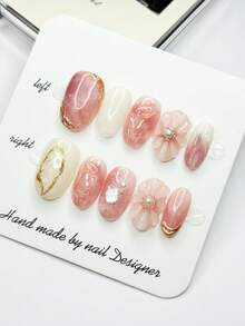 10 móng giả hình oval cỡ trung bình với tông màu hồng nude và trắng nhạt chủ đạo, cánh hoa 3D (đính ngọc trai), đường viền lá vàng, mảnh vỏ sò óng ánh tạo nên không gian lãng mạn và tinh tế, móng acrylic dán thủ công 100% có thể tái sử dụng dành cho nữ dùng hàng ngày hoặc dự tiệc. - Nhiều màu - Xem 6