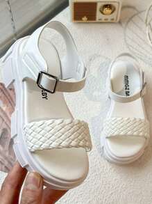 A Pair Of Children's/Girls' Sandals. The Main Body Of The Upper Is White. The Cross-Woven Straps Are In A Combination Of And Pink. There Is A Metal Buckle Strap At The Ankle.