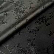 一块梅花图案的提花缎面料，质地柔软，深色提花面料，精致典雅，是DIY手工和缝纫的完美选择