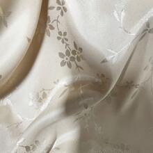 一块梅花图案的提花缎面料，质地柔软，深色提花面料，精致典雅，是DIY手工和缝纫的完美选择