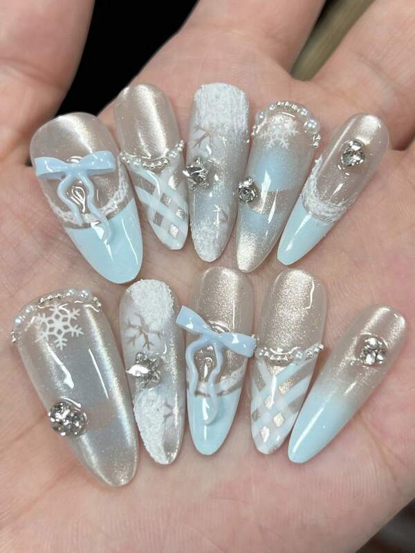 1 set de 10 décalcomanies d'ongles en forme d'amande magnifiquement conçues avec des motifs de flocons de neige et du gesso blanc. Le design comprend des ongles français bleus dégradés avec des yeux de chat peints à la main dans un style Y2K, des lignes bleues, des formes de diamant, des coupes en damier et des flocons de neige. Le set comprend également des chaînes de billes en acier, des perles, des grappes de strass et un vernis gel de finition.