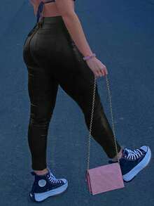 Pantalones pitillo de cintura media de cuero sintético para mujer con bolsillos en diagonal, una elección perfecta para los atuendos navideños.