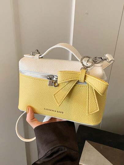 时尚新款优雅纯色PU皮手提包，迷你方形PU包，黄白配色，防水材质，不对称拉链装饰设计，撞色缝线设计，可作午餐盒包，蝴蝶结吊坠装饰，适合旅行、购物、聚会和通勤。