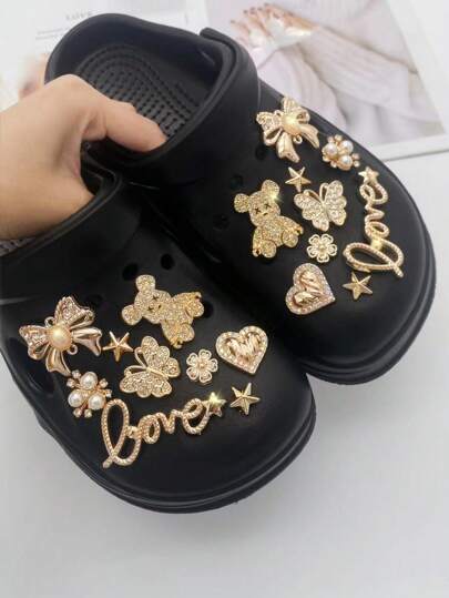 18 قطعة من الإكسسوارات الذهبية للأحذية والملابس، تشمل سلاسل ذهبية، فتيات راقصات، فيونكات كبيرة، نجوم، علامات دولار، أحذية مفرغة، زهور بلورية واصطناعية، مناسبة للنعال والصنادل والزينة، هدية مثالية للمناسبات