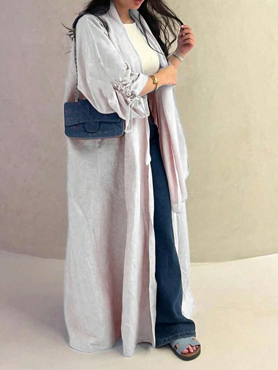 Chiếc áo choàng nữ cổ điển thanh lịch với dây rút ở cổ tay này toát lên vẻ quý phái và duyên dáng, phù hợp cho mọi mùa và nhiều sự kiện văn hóa khác nhau. - Màu Xám nhạt - Xem 1