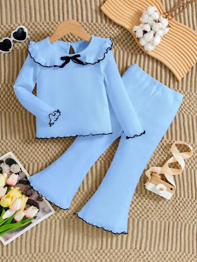 Elegant vit stickad långärmad topp och utsvängda byxor för flickor. Raffinerad och minimalistisk vit design med rosettdetaljer, utsvängda ben, bekväm och ren men ändå elegant. Lämplig för vardagsbruk och utflykter, vår/höst