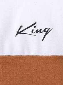 Ung pojke med bokstavstryck, färgblock och rund halsringning, tröja och mjukisbyxor, avslappnad outfit