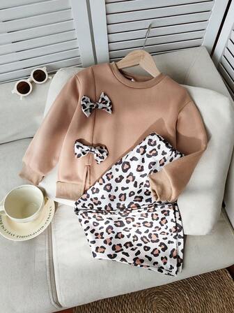 بلوزة فليس مزينة بالفراء والفراء الفهد مع فيونكة، مقترنة مع بنطلون فليس مطبوع بنمط الفهد، مناسبة للخروج والألعاب الخارجية في فصل الخريف والشتاء