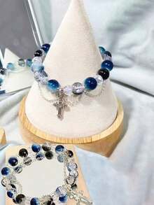 1pc Cool Blue Cross Bracelet. Transparent Blue Crystals Are Strung Together To Form The Chain, Adorned With A Silver Cross Pendant, Exuding A Cool And Crisp Vibe. The Blue Hue Resembles The Deep, Luminous Depths Of The Ocean, While The Cross Features Clean, Sharp Lines. The Silver Chain Is Delicate And Hugs The Wrist Comfortably. Under The Play Of Light And Shadow, The Crystals Refract Delicate Blue Hues, And The Silver Accents Shimmer With A Matte, Cool White Glow. Whether Worn Alone Or Layered With Other Pieces, It Evokes A Sense Of Detachment And Minimalist Elegance, Perfectly Complementing Minimalist Outfits And A , Tranquil Aesthetic.Perfect Gift For Birthdays, Holiday Gifts, And Parties. Suitable For Daily Wear And Holiday Celebrations, Suitable For All Seasons, And Is An Ideal Choice For Holiday Accessories. - Blue - 查看 3