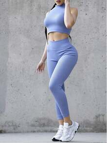 Conjunto deportivo de dos piezas para mujer, ideal para entrenamiento, gimnasio, yoga o estilo urbano. Top corto sin mangas de cuello alto y leggings largos de cintura alta, confeccionados en tejido acanalado elástico que moldea la figura y proporciona máxima comodidad. Diseño ceñido que realza las curvas, perfecto para un look activo, moderno y favorecedor. Apto para uso diario o actividades deportivas - Azul - Ver 1