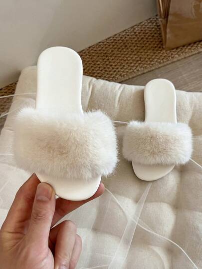 A Pair Of Children's Fluffy Slippers, With A White Main Body And A Circle Of Soft And Fluffy White Fur On The Upper, Have A Simple And Cute Overall Design. They Are Suitable For Children Aged 3 To 12 To Wear At Home, Providing Them With A Warm And Comfortable Experience.