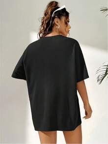 SpongeBob SquarePants Áo thun ngắn tay màu đen dáng rộng in hình hoạt hình. Hình SpongeBob mặc bộ đồ ngủ màu vàng xanh phối hoa tím, cười tươi và ôm một chiếc gối trắng. - màu đen - Xem 2