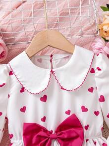 Rochie pentru fete cu imprimeu de inimă, guler Peter Pan, albă, imprimeu integral cu inimioare roz, guler Peter Pan și design cu fundă mare, stil dulce de prințesă. Potrivită pentru petreceri de ziua de naștere, dans, spectacole școlare. Primăvara, toamna, iarna.