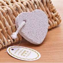 Frotar los pies con piedras flotantes para eliminar los callos, moler los pies con piedras en forma de corazón