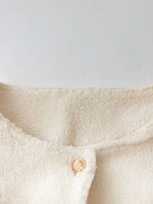 Chaqueta corta de mujer con cuello redondo, botones metálicos delanteros, mangas raglán y dobladillo con volantes en color amarillo mostaza