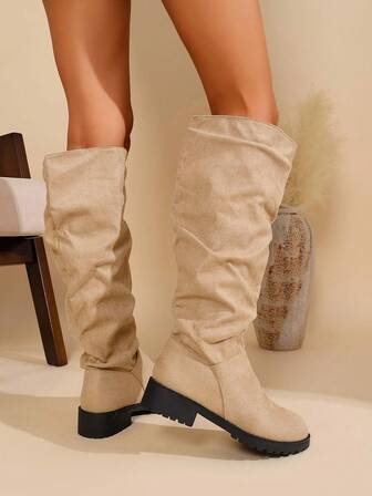 Moderiktiga stövlar med mellanhög klack och överknee designade för tonårsflickor med resår och dekorativa remdetaljer. Allt-i-ett-stövlar