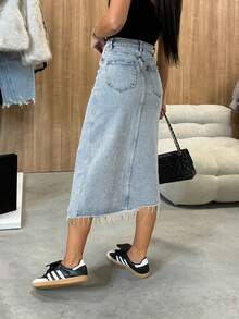 Damska spódnica jeansowa w miejskim stylu, która dopasowuje się do kształtu nogi i ma wysoki stan, rozcięcie i surowe wykończenie. Nadaje się do noszenia na co dzień z różnymi bluzkami i sprawdzi się na co dzień, na zakupach, spotkaniach ze znajomymi i innych wyjściach.