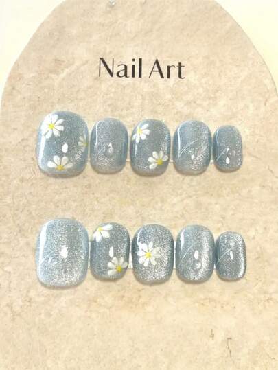 10 Stücke handgefertigte kurze ovale tragbare Nail Art Nägel. Mit einem leicht luxuriösen Y2K-Hellblau mit feinem Glitzer und einem kleinen Gänseblümchen-Design. Sie lassen Ihre Haut fair aussehen, sind romantisch, abnehmbar und wiederverwendbar, geeignet für weibliche Freunde verschiedener Stile für den täglichen Gebrauch.