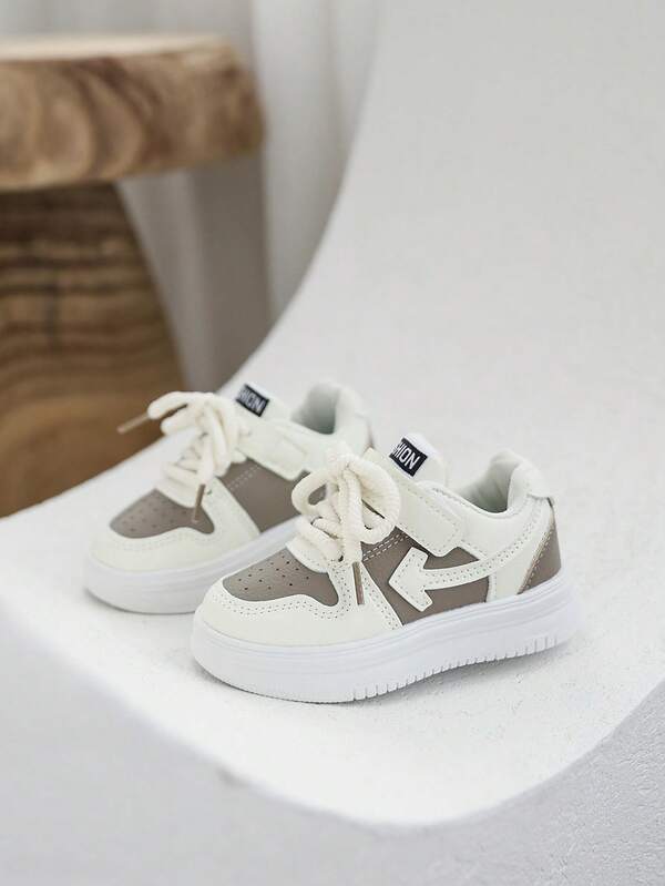 A Pair Of Children's Casual Sneakers, Featuring A Soft Leather Upper, Breathability, Leather Splicing, And Adjustable Strap. It's A Round-Toe Low-Top Sneaker, Suitable For Outdoor Travel, Sports, And Casual Wear