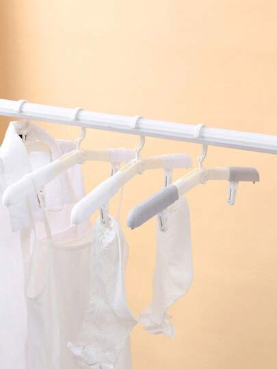 1 pieza Percha de ropa plegable multifuncional para viajes, percha de ropa plegable portátil para viajes y viajes de negocios. Percha de ropa plegable mini para el hogar. Artículo de uso doméstico y diario, almacenamiento en el armario de ropa. Se puede colgar para guardar.