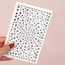 这款3D水晶面部贴片，让你轻松打造节日派对必备的吸睛造型！无论是锐舞派对、主题派对还是其他场合，都能瞬间增添耀眼光芒。大小不一的水晶营造出层次丰富的3D效果，在照片和灯光下熠熠生辉。使用方法简单——只需撕下背胶，贴在干净的皮肤上即可（无需胶水！）