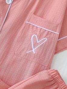 مجموعة بيجامة تتكون من 2 قطعة للنساء، ملابس علوية بأكمام قصيرة بجيب وتطريز قلب على الياقة، وبنطلون بفيونكة، لون سادة مع تريم متباين، مناسبة للاستخدام المنزلي