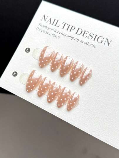10片装手工可佩戴美甲贴片，短款杏仁形按压式假指甲，流行时尚款式，亮粉色底色搭配流行的白色波点图案，是一款高端美甲贴片产品，适合女性和女孩日常佩戴，套装包含美甲用品和手工按压式假指甲。