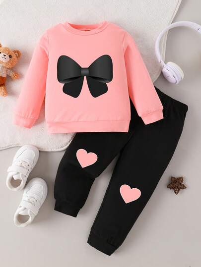 Conjunto de 2 piezas de top de manga larga con cuello redondo y estampado de moño, y pantalones con estampado de corazón, para niñas bebés, para otoño/invierno