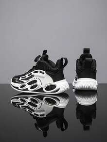 Un par de zapatos deportivos de malla de moda para niños, con perilla giratoria para abrir, destacan en el juego casual y las competencias deportivas