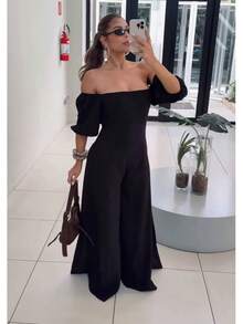 The Look That Exudes Tropical Elegance With Attitude! The Itacaré Jumpsuit Is Pure Charm For Stylish Summer Days. It Features Puff Sleeves And An Off-The-Shoulder Neckline. A Tie Detail At The Back Enhances The Silhouette. Comfort And Visual Impact In A Single Piece. - 黑色 - 查看 1