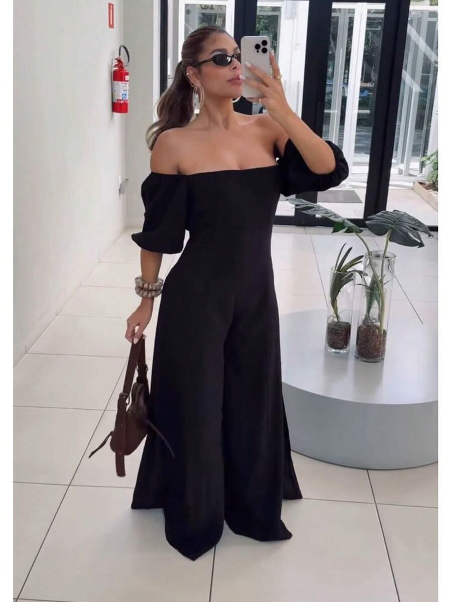 The Look That Exudes Tropical Elegance With Attitude! The Itacaré Jumpsuit Is Pure Charm For Stylish Summer Days. It Features Puff Sleeves And An Off-The-Shoulder Neckline. A Tie Detail At The Back Enhances The Silhouette. Comfort And Visual Impact In A Single Piece. - 黑色 - 查看 1