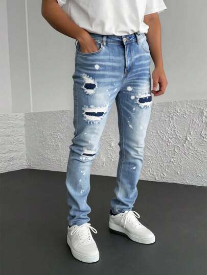 Pantalones vaqueros azules con rotos y efecto de salpicadura, tiro alto y corte entallado, estilo vanguardista y personal