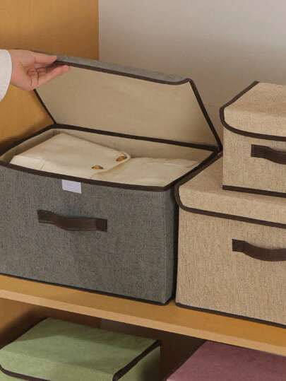 1 hộp đựng đồ bằng vải có nắp gập, đa chức năng, dùng để sắp xếp quần áo, quần dài, đồ dùng cần thiết trong nhà.