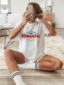 Camiseta con estampado Romantic y frase I live in the moment, ideal para amantes del romanticismo. Camiseta oversized para damas en colores blanco y negro con estampados de letras, flores y anime. Diseño trendy combinado con elementos de estampado, estilo casual, con función de adelgazar, pieza básica y versátil, divertida y ideal para atuendo diario, vacaciones y looks callejeros.