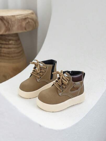 A Pair Of Children's Leather Boots, Waterproof And Shock-Resistant, With A Soft Leather Surface For Comfortable Wearing. It Features A Mid-Top Round Toe Design, Suitable For Children's Outdoor Leisure And Travel