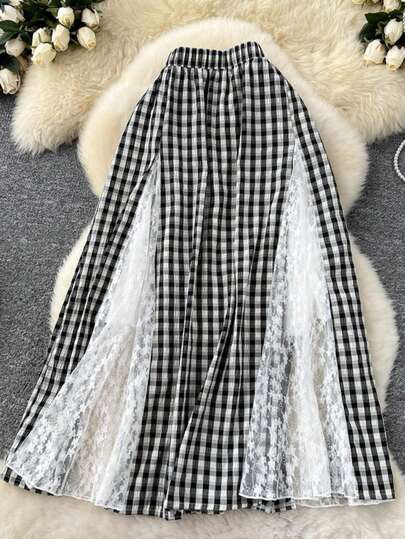 تنورة مخططة بنمط أسود وأبيض على شكل خطوط مائلة مع تطريز دانتيل مفرغ وطيات أنيقة