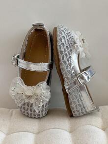 这款女童皮鞋采用银白色蕾丝鞋面，鞋头饰有白色亮片蝴蝶结，并配有银色魔术贴搭扣。设计甜美精致，可搭配公主裙及其他服饰，适合生日派对、儿童演出等各种场合。 - 銀色 - 查看 7
