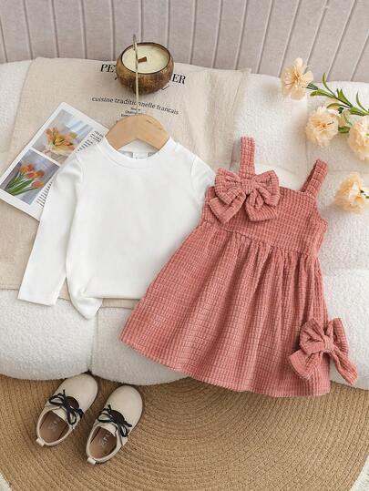 秋冬新款女宝宝高领长袖上衣加围兜连衣裙3D蝴蝶结，柔软的白色高领汗衫如云朵般包裹着小宝宝，亲肤百搭，粉色灯芯绒围兜连衣裙3D蝴蝶结装饰，走路都带着“甜美气息”，搭配仿珍珠皮鞋，打造优雅小公主造型，适合日常出游、学前活动，或是周末家庭出游