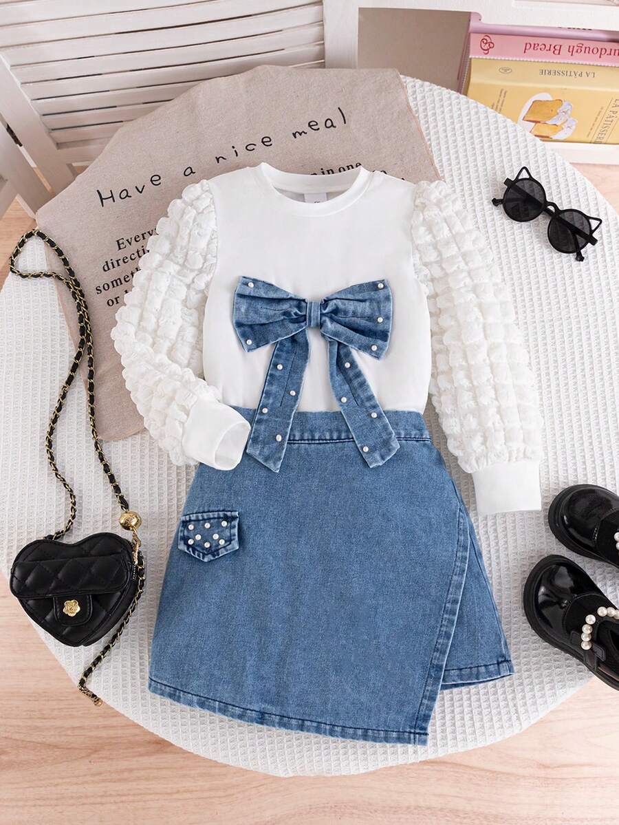Young Girl Spring/Autumn White Puff Sleeve Round Neck T-Shirt With Bow & Pearl Decor, Paired With Elegant Casual Asymmetric Denim Skirt With Pearl Pocket Flap, 2-Piece Set Suitable For School, Outdoor, Commute, Vacation, Photography, Daily Wear